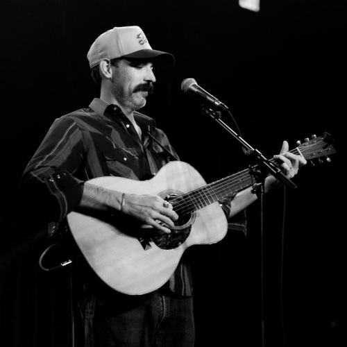 a man playing a guitar on a stage