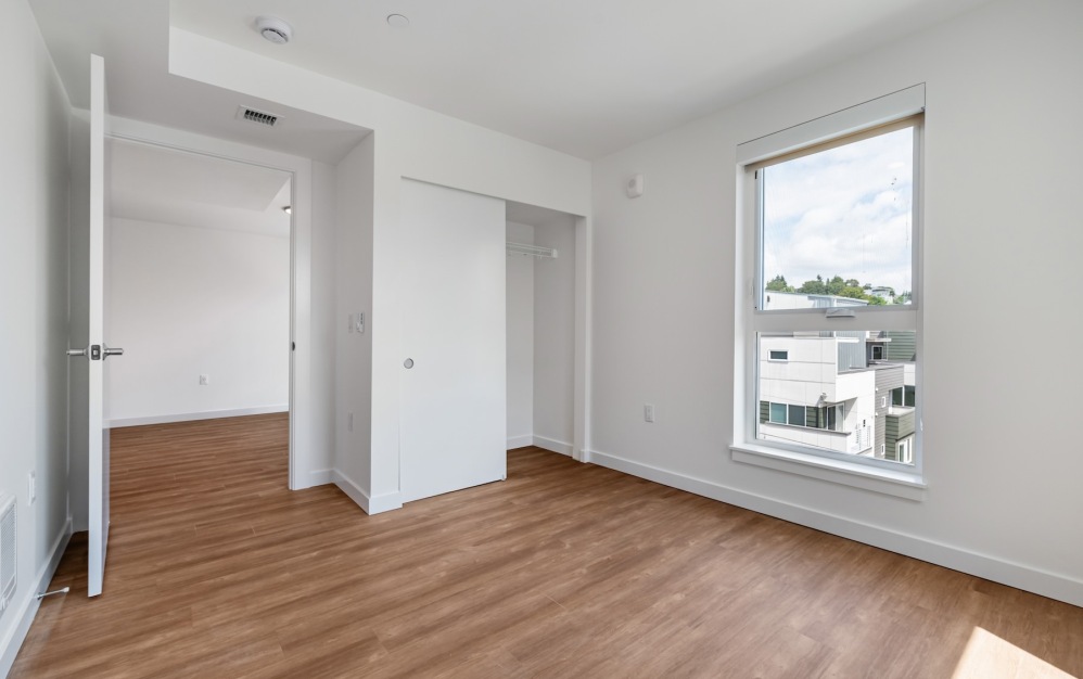 a bedroom with wood floors and a window