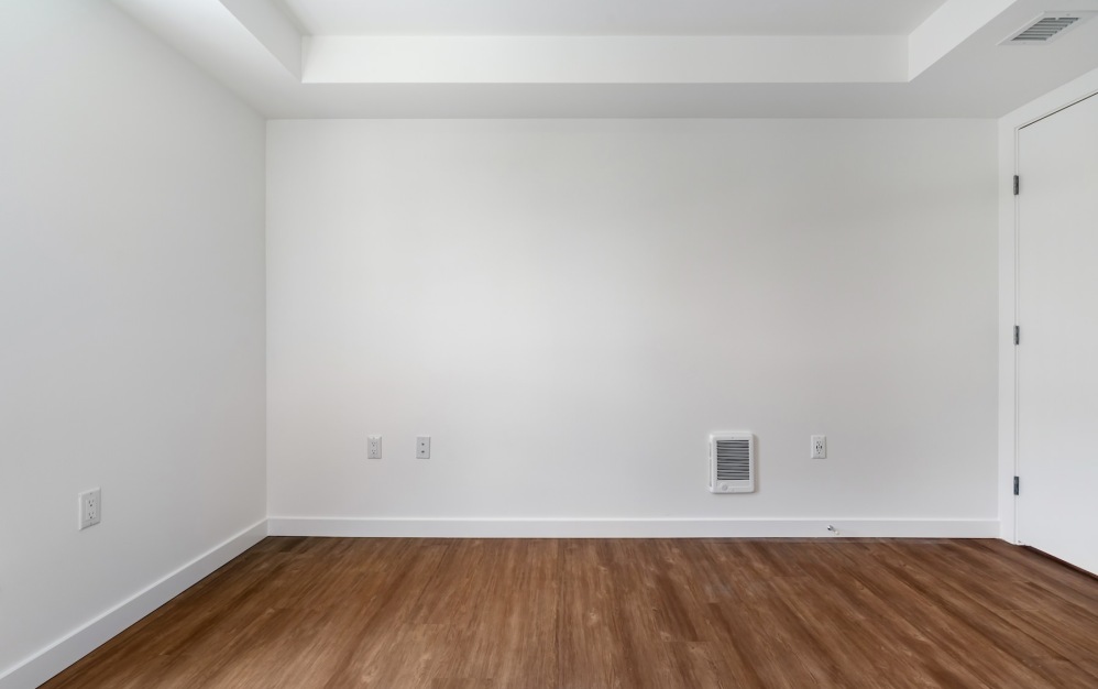 a bedroom with wood floors and white walls