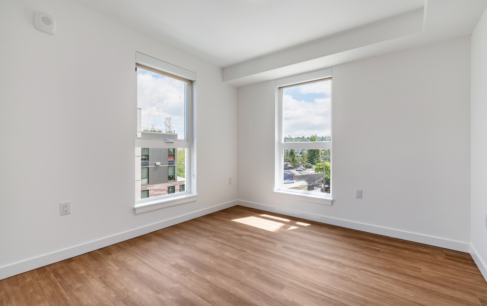 a bedroom with wood floors and windows