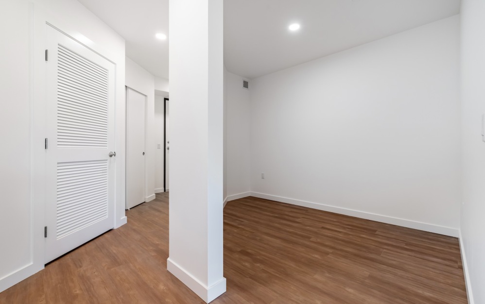 a den space with wood floors and white walls