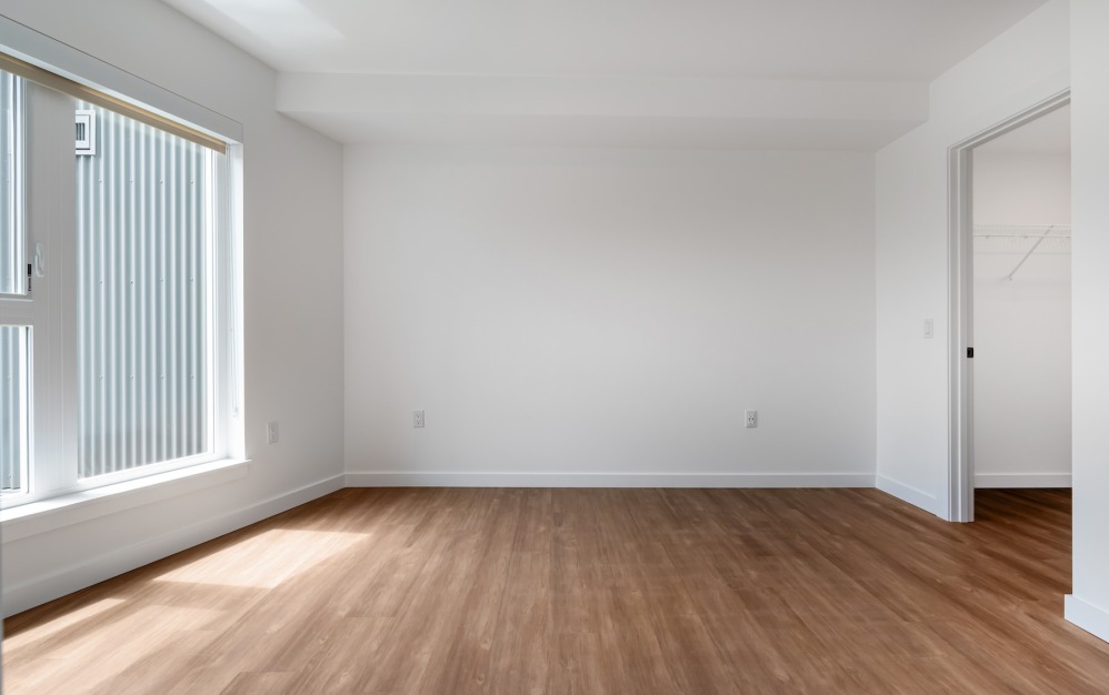 a bedroom with white walls and a window