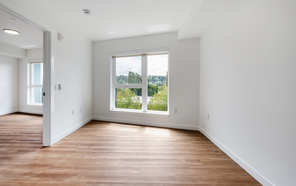 a bedroom with wood floors and a window