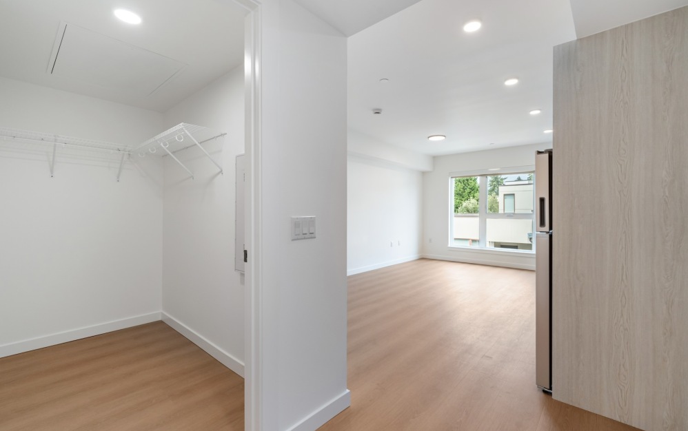 a closet and living room with wood floors