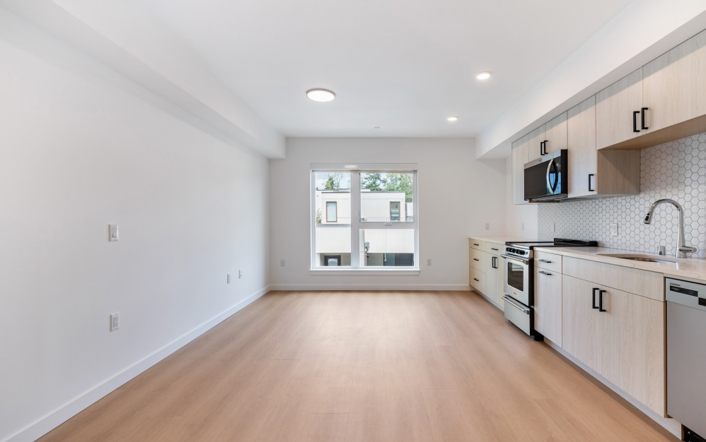 a living room and kitchen with wood floors and a window